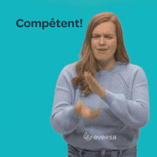 a woman wearing a blue sweater applauds in front of a blue background that says competent
