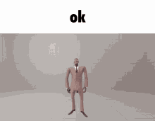 a man in a suit is dancing in front of a white background with the word ok on it
