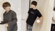a couple of young men are standing next to each other in a room .