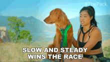 a woman sits next to a dog with the words slow and steady wins the race