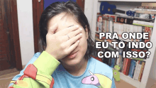 a woman covering her face with her hand and the words pra onde eu to indo com isso below her