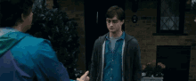 two men are shaking hands in front of a brick building .