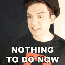 a man wearing a hat and a black shirt with the words nothing to do now on it