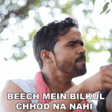 a man with the words beech mein bilkul chhod na nahi written below him