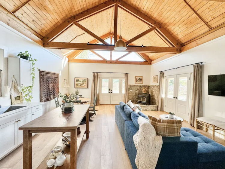 Open plan living space with kitchen counter tops, a table and  blue linen sofa .