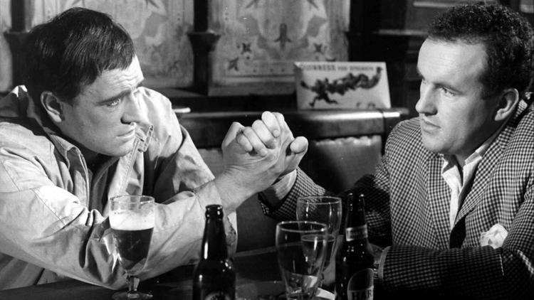 A still from the black and white film This Sporting Life of two men arm wrestling  