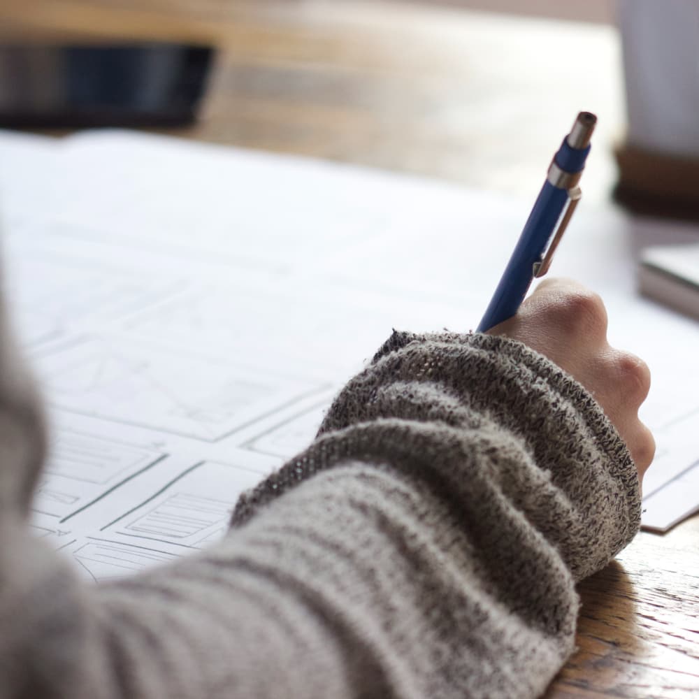 Right arm holding pencil writing on paper.