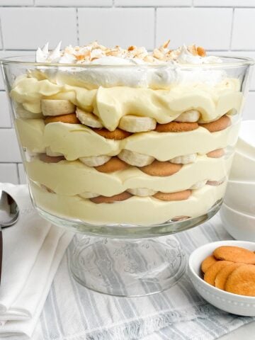 easy banana pudding in a trifle dish on a blue and white napkin