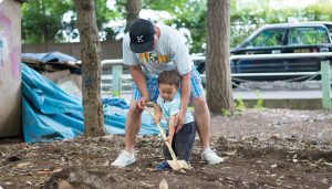 息子とショベルで土を掘る父親