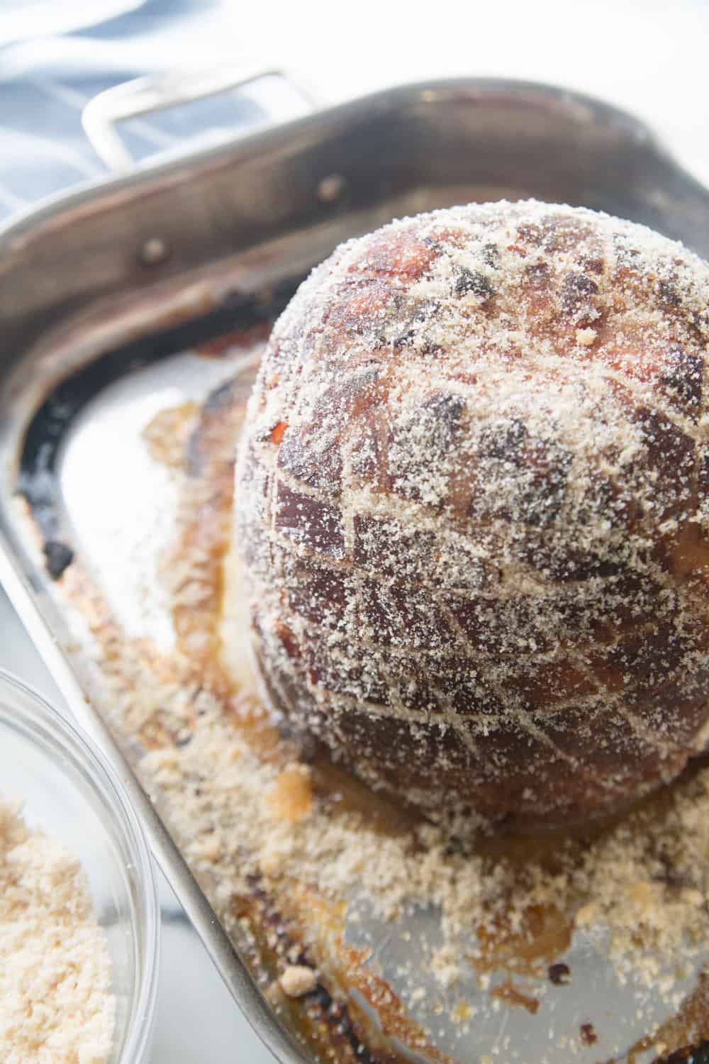 honey glazed ham with sugar rub on a cooking sheet on a white counter