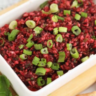 Cranberry Jalapeno dip topped with green onions in a white rectangle dish.