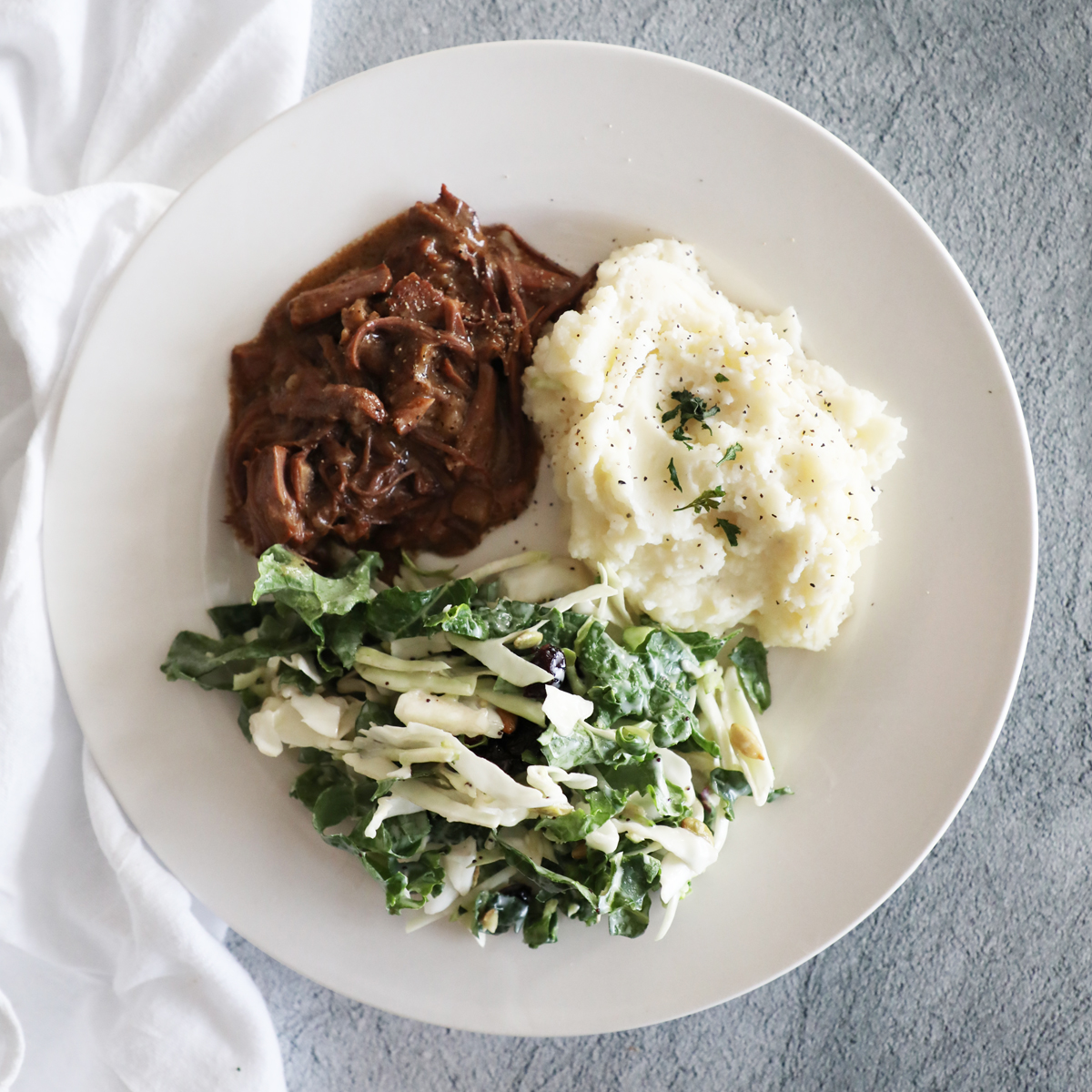 Bird's eye view of pepsi pot roast, mashed potatoes, and salad.