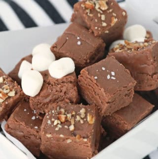 Marshmallow Cream Fudge squares with different toppings - marshmallows, pecans ad sea salt - in a small white dish.