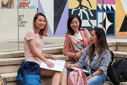 Female student group sitting outside and talking