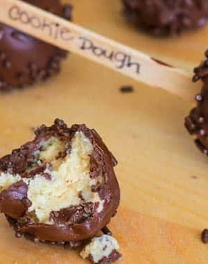 cookie dough covered in chocolate, sprinkles, on a popsicle stick