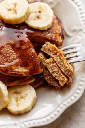 close-up of cut banana pancakes on white plate.