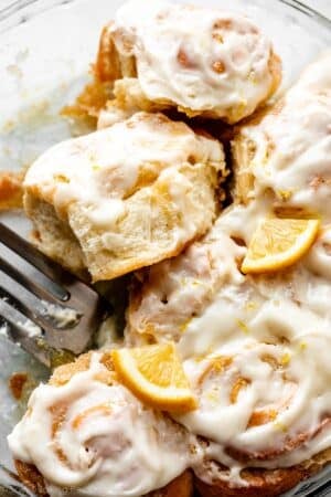 lemon sweet rolls with lemon cream cheese icing in glass dish.