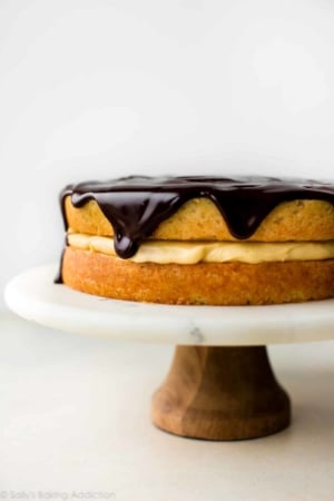 Boston cream pie on a wood and marble cake stand