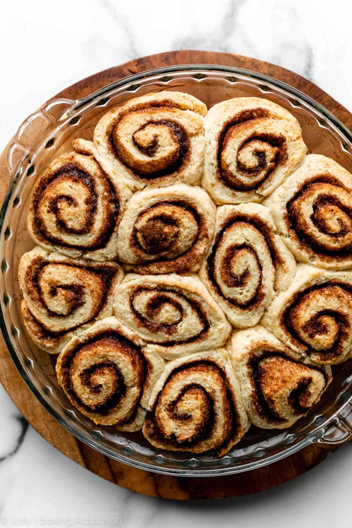 12 no yeast cinnamon rolls in glass pie dish.