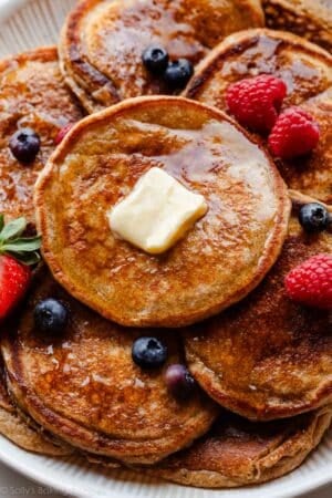 whole wheat pancakes with syrup, berries, and butter.