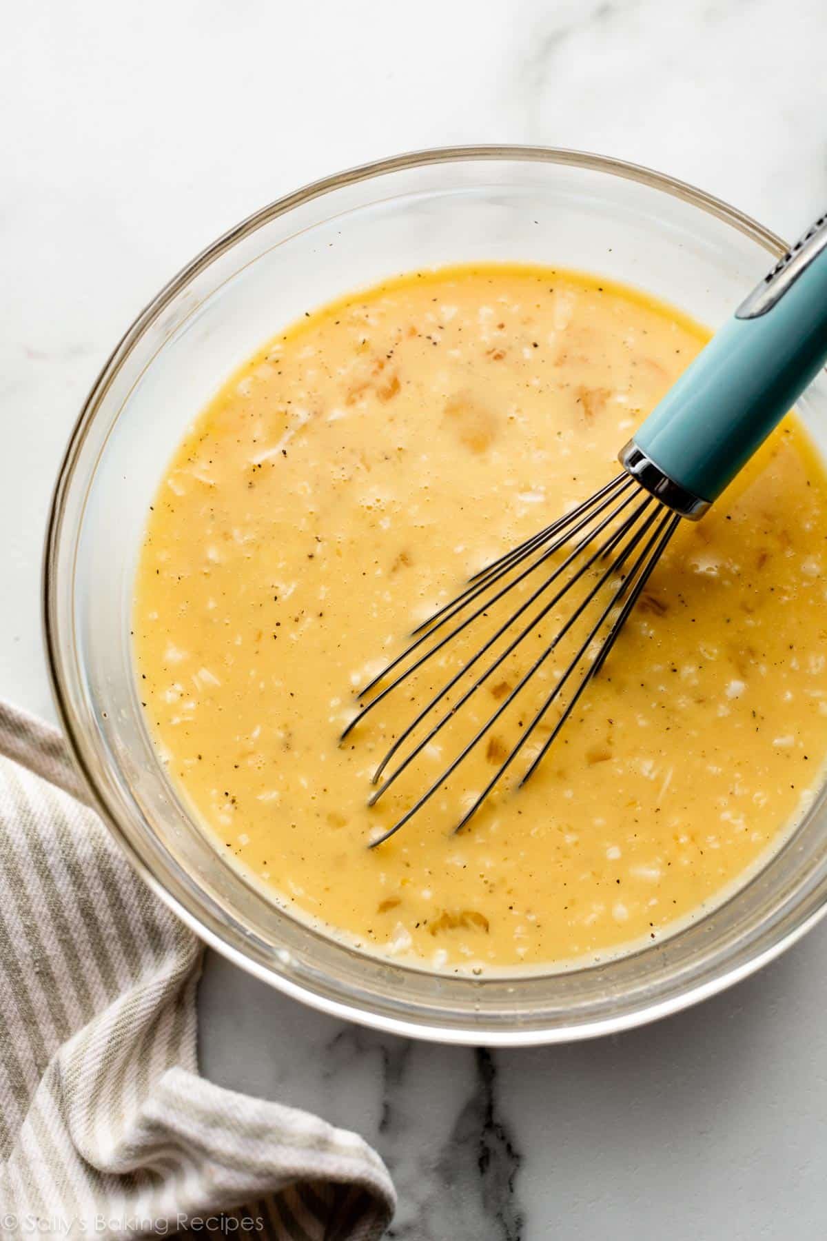 beaten egg and cheese mixture in glass bowl.