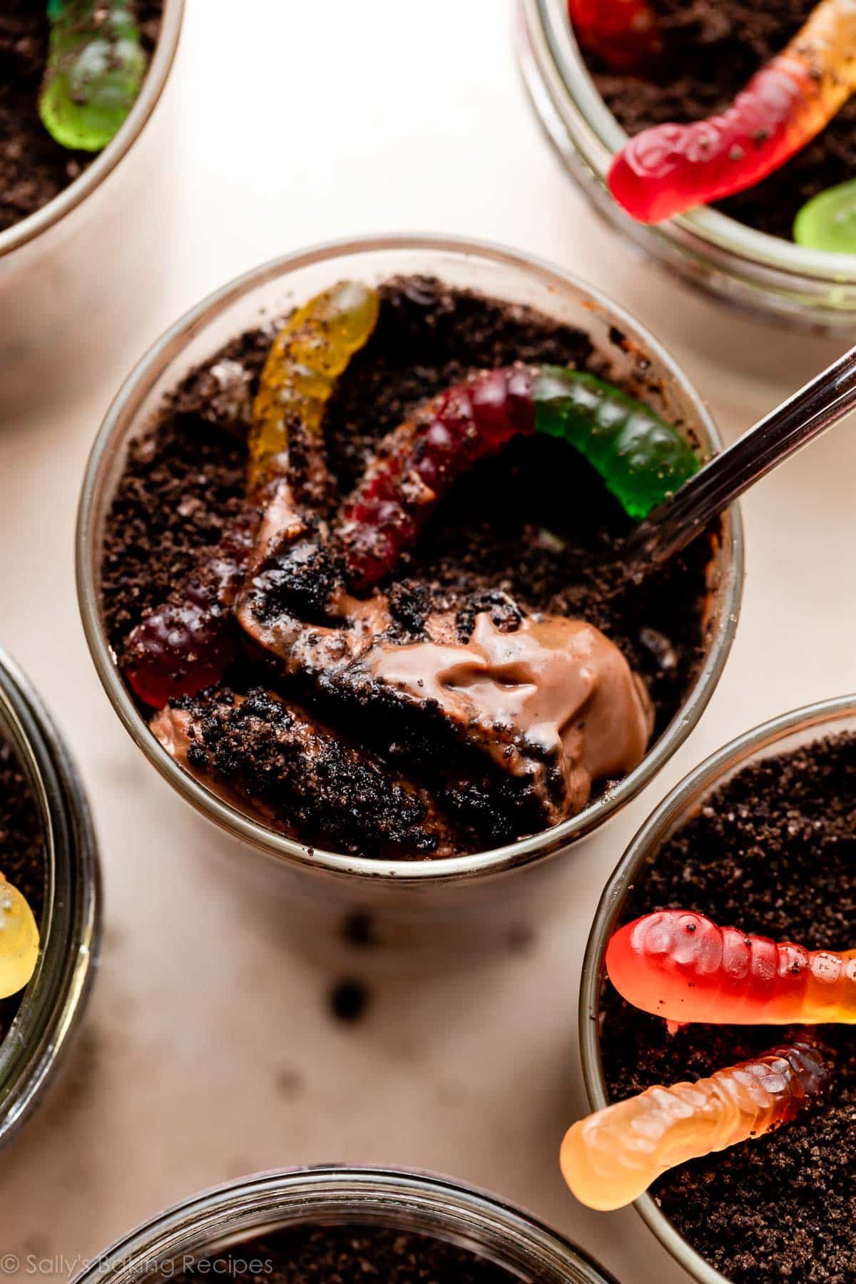 overhead picture of dirt pudding cups with crushed Oreo cookies and gummy worms on top.