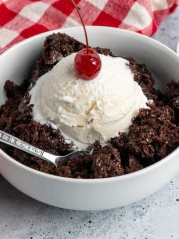 Crock pot choccolate lava cake with ice cream and a cherry on top.