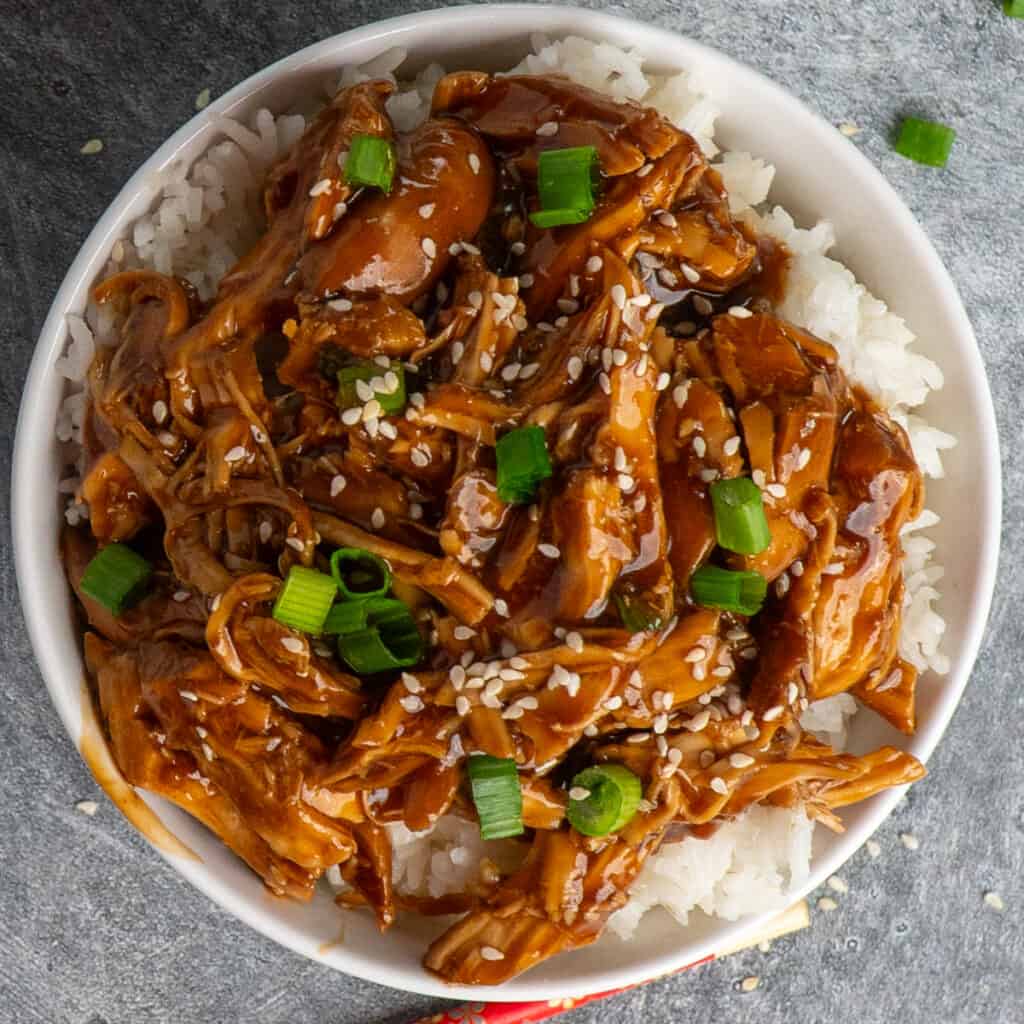 Overhead look at teriyaki chicken rice bowls garnished with green onions.