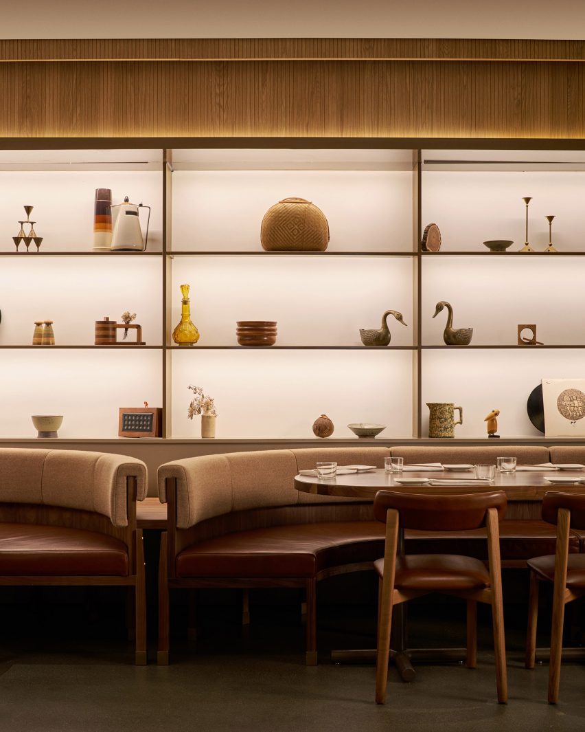 Light boxes behind objects displayed on shelves, above banquette seating