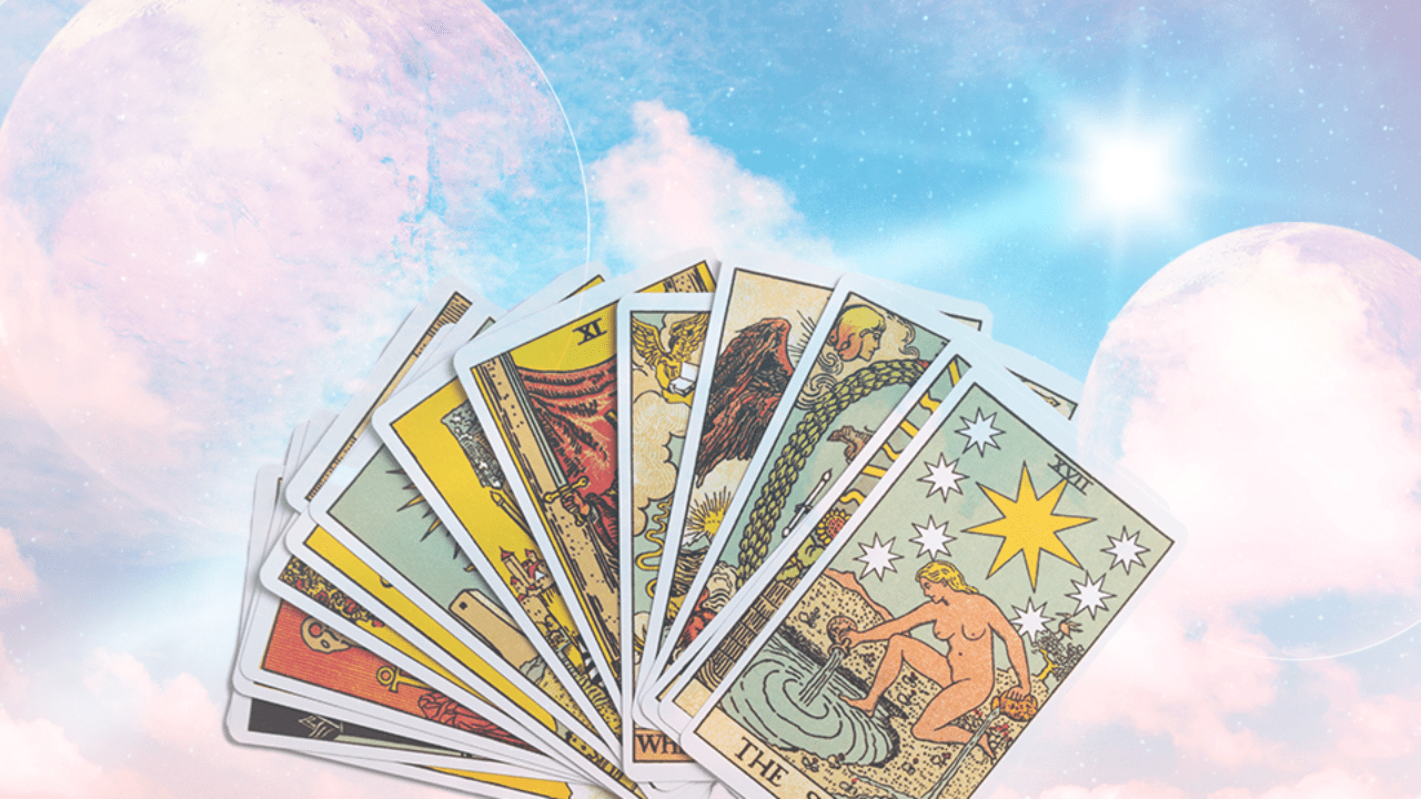 A hand of Tarot cards displayed over a cloudy and celestial blue sky background