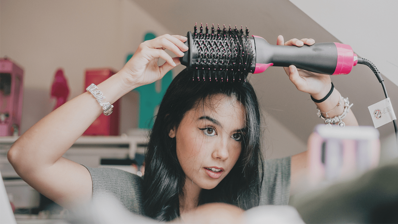 Woman using a hair straightening brush.