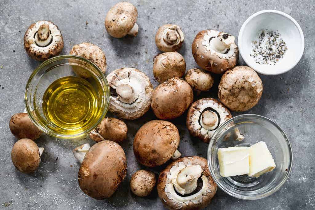 The ingredients needed to sauté mushrooms, including mushrooms, butter, oil, salt and pepper.