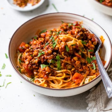 a bowl of pasta with lentils and red sauce