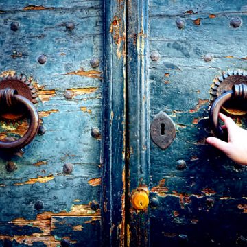 young woman opening a medieval door