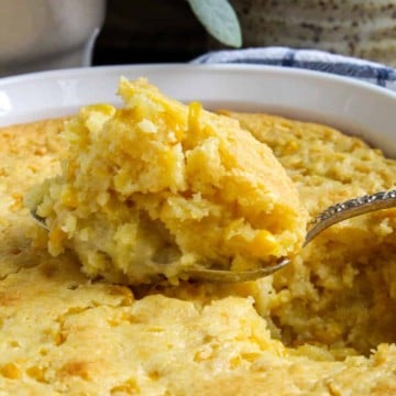 Close up of spoonful of corn soufflé coming out of casserole.