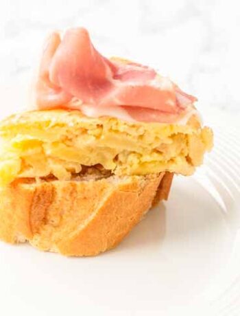 Spanish tortilla on white bread tipped with serrano ham