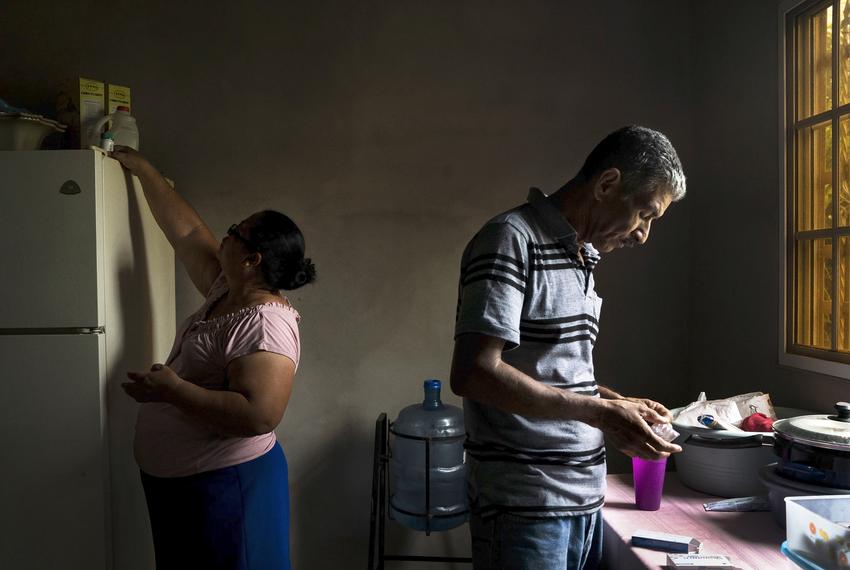 Carlos' parents, Rosa, left and José, right, who live in Olancho, Honduras, take their daily medication for various illnesses such as diabetes, thyroid disease and high blood pressure. Their daughter Lilian, who migrated to Los Angeles, California 14 years ago, has been providing for them ever since.