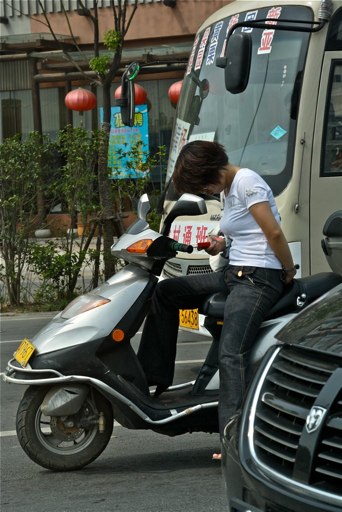 File:Woman texting on motorcycle.jpg