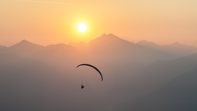 Paraglider at sunrise, seen from Hahnenkamm mountain, Reutte/Tyrol