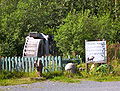 The sign reads "Moose Pass is a peaceful little town, if you have an axe to grind, do it here." Good advice