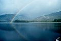 An Alaskan rainbow - note reflection on the water.