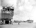 LST-325 (left) and LST-388 unloading while stranded at low tide during resupply operations, 12 June 1944.