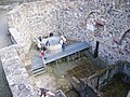 Blick auf Burgbrunnen mit moderner Abdeckung und historischer Zisterne