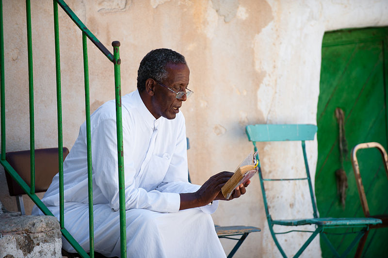 File:A priest reads outside Sepulchre.jpg