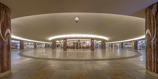 The Opernpassage in Vienna, a pedestrian underpass of the most busy crossroads of the city near the opera house, was built in 1955 and opened on 4 November 1955, one day before the reopening of the Vienna State Opera after World War II. Planned by Adolf Hoch it has been a symbol for a modern spirit in architecture and urban planning. Cooperating with the Federal Office for the Protection of Monuments in Austria the City of Vienna undertook a complete restoration of the structure, which was reopened on 17 September 2013. It shows the original design of the round columns, the curved glass of the shop windows, and the chequerboard pattern of the floor.