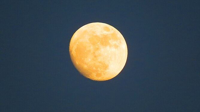 yellow illuminated moon in the dark blue sky