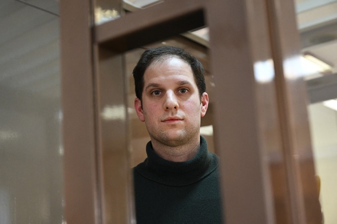 US journalist Evan Gershkovich, arrested on espionage charges, looks out from inside a defendants' cage before a hearing to consider an appeal on his extended pre-trial detention, at the Moscow City Court in Moscow on February 20, 2024. Wall Street Journal reporter Evan Gershkovich was detained last March on spying charges during a reporting trip to the Urals. (Photo by NATALIA KOLESNIKOVA / AFP) (Photo by NATALIA KOLESNIKOVA/AFP via Getty Images)