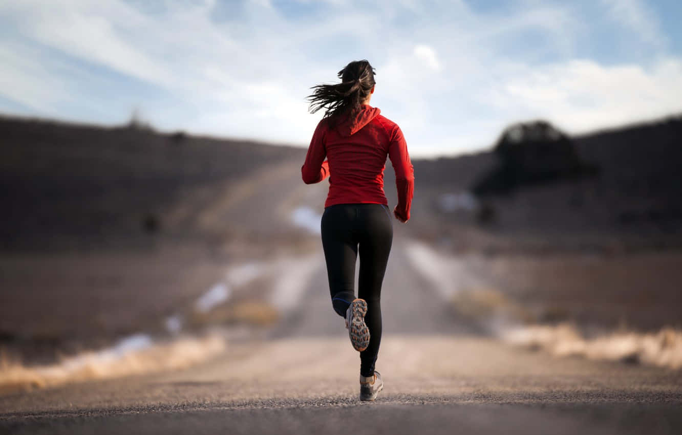 Determined Female Athlete Training for Marathon Wallpaper