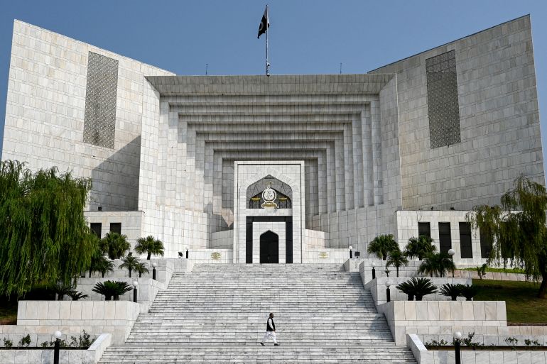 A man walks past the Pakistan's Supreme Court building in Islamabad on October 23, 2024, as Justice Yahya Afridi, who was nominated by a Special Parliamentary Committee (SPC), is going to take oath as the next chief justice of Pakistan (CJP). (Photo by Farooq NAEEM / AFP)