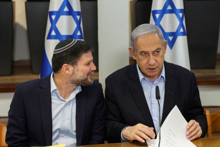 Israeli Prime Minister Benjamin Netanyahu speaks with Minister of Finance Bezalel Smotrich during the weekly cabinet meeting at the Defence Ministry in Tel Aviv, Israel, January 7, 2024. REUTERS/Ronen Zvulun/Pool